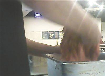 在開餐前，烤肉店一名員工正徒手攪拌肉片。
